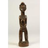 Houten gestoken Baule sculptuur van staand vrouwenlijk figuur, Ivoorkust, h. 32 cm.Wooden carved