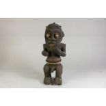 Houten gestoken Mambila sculptuur van hurkende mannen figuur, met deels polychroom gedecoreerd,