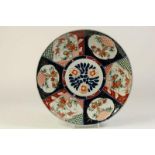 Porseleinen Imari schotel met centraal decor van bloemen en randdecoratie van cartouches met