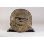 Houten gestoken Eket zonmasker met spleetogen en gesloten mond, Nigeria, l. 34p cm.Wooden carved