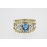 Bicolor ajour ring bezet met blauwe topaas en diamant briljant slijpsel ca. 0.70ct., geh. 585/000