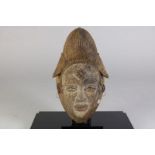 Houten gestoken Punu damesmasker met spleetogen en gesloten mond, Gabon, l. 32 cm.Wooden carved Punu