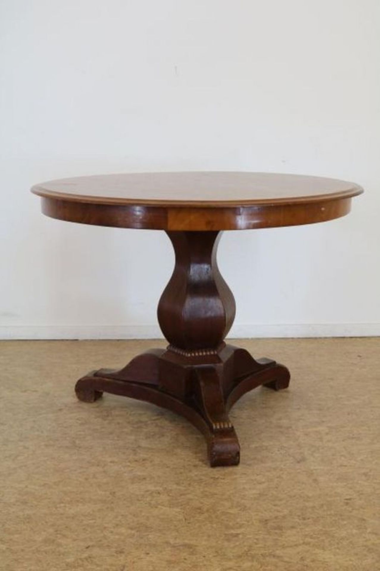 Mahonie Biedermeier tafel op vaaspoot uitlopend in 3-sprant, 19e eeuw, h. 75, diam. 100 cm.
