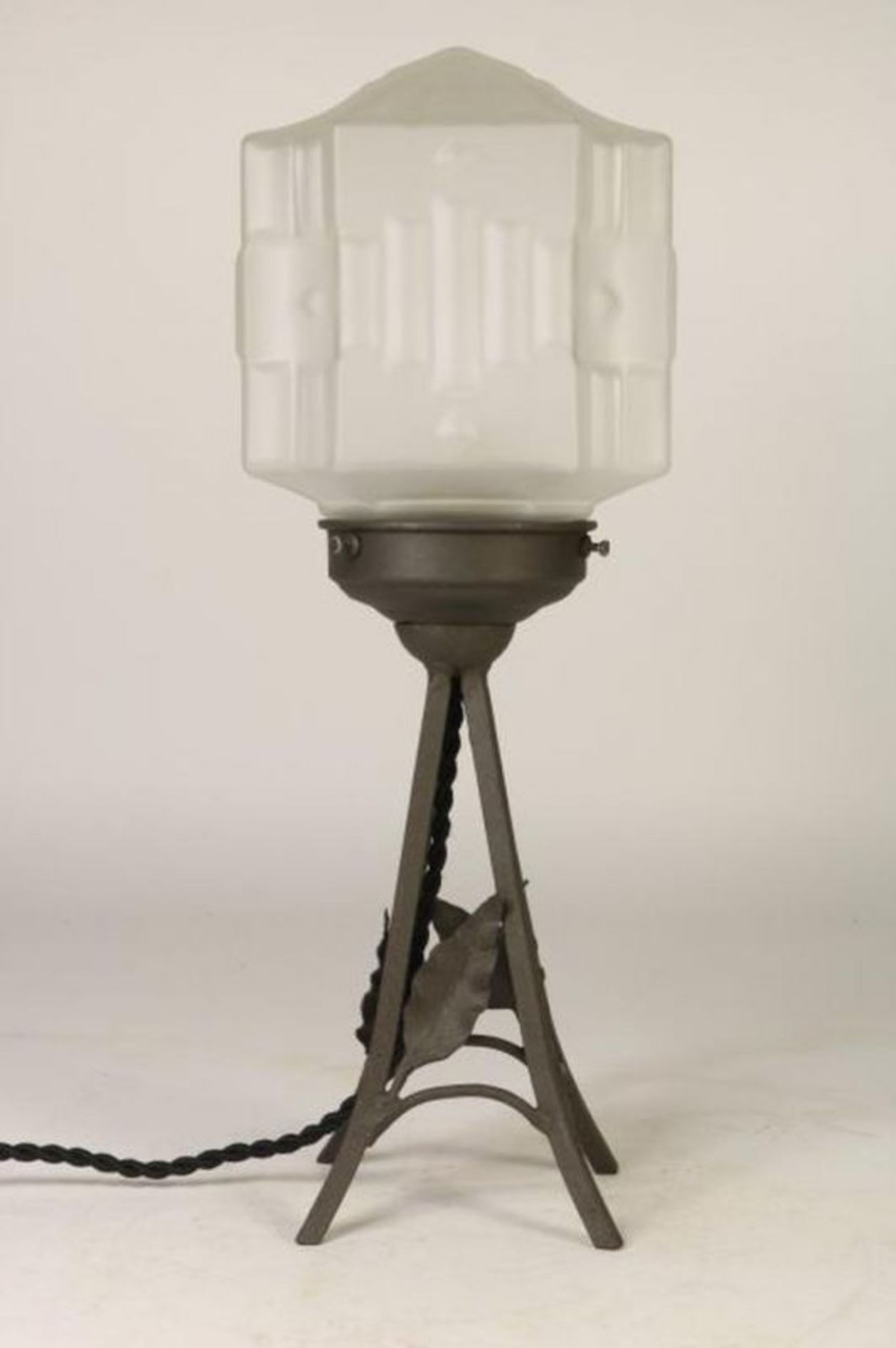Art Deco tafellamp op smeedijzeren voet en gesatineerde glaskap, h. 37 cm.