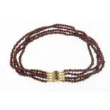 4-rijig granaten collier aan gouden slot, l. 33cm. A garnet necklace with rose golden locket