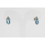 Witgouden oorbellen bezet met blauw topaas en diamant, geh. 750/000 A pair of white gold earrings