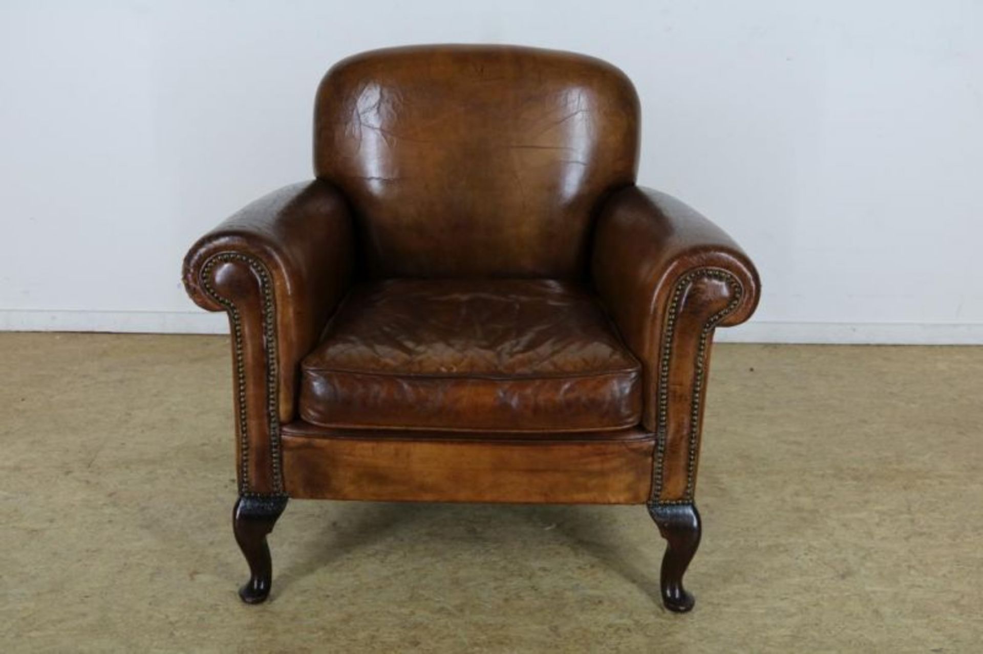 Bruin lederen fauteuil op Queen-Anne-stijl pootjes, ca. 1920.