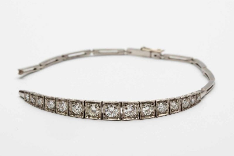 Witgouden armband, ca. 1930,middenstuk met vijftien aflopende vierkante schakels, ieder gezet met