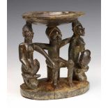 Yoruba, two carved wooden Ifa oracle bowls,suported by carved figures. With remnants of pigments.