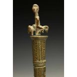 Yoruba, brass tappersurmounted by figure on horse, the conical column decorated with incised