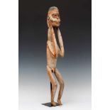 Papua Barat, Central Asmat, standing figurewith flexed legs and hands touching the head. With