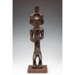 West Angola, Chokwe, standing mounted King-figure with two hands bent in front of chest, elaborate