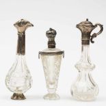 Drie kristallen parfumflacons, 19e eeuw,alle met zilveren montuur. Eén met dop in de vorm van een