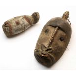 Maprik, two wooden anthropomorphic heads,the larger with cowry shells, with traces of pigments. ; h.