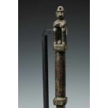 Moluccas, wooden measure stick, topped by a squatting male figure,the lower part shaped as a