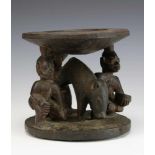 Nigeria, Yoruba, carved wooden Ifa oracle bowl,three carved figures with two holding the support