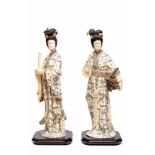 Paar met buffelbot belegde houten vrouwfiguren, 20ste eeuw,met fraai gegraveerde robes en ceintuurs,