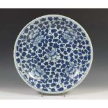 China, blauw-wit porseleinen schotel, 18e eeuw,met vol bloesemdecor (schilfertje); diam. 37,5 cm.;