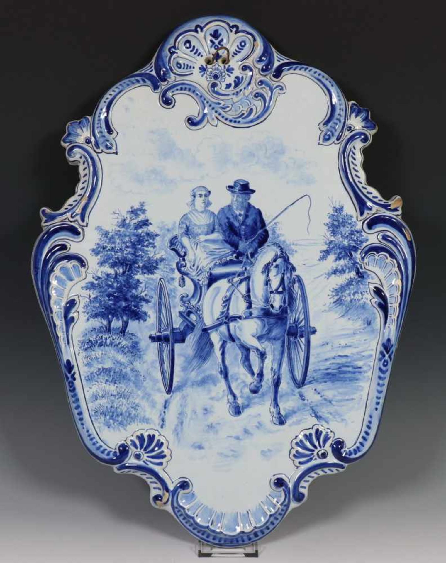 Tichelaar, blauw-wit aardewerk plaquette, eind 19e eeuw,met decor van koets, de gecontourneerde rand