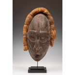 PNG., North Coast, Vokeo wooden mask, with traces of red rectangular motifs and a beaten bark