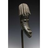 Nigeria, Ijo, mask,narrow mask with hairstyle in braids and painted in silver and black. Kathy van