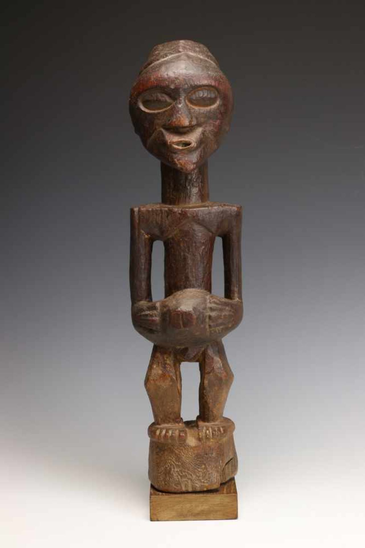 DRC., Songhe, male power figure,with hands on bulbous extention on the stomach, the face with