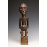 DRC., Songhe, male power figure,with hands on bulbous extention on the stomach, the face with