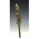 Yoruba, Ogboni, brass Edan staffsurmounted by seated male figure with fan and staff in hand.