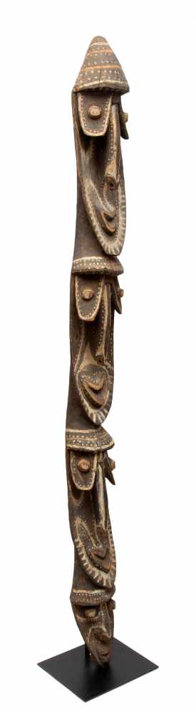 Papua Nieuw Guinea, Sepik, Maprik area, wooden pole sculpture with multiple facesdetails in red