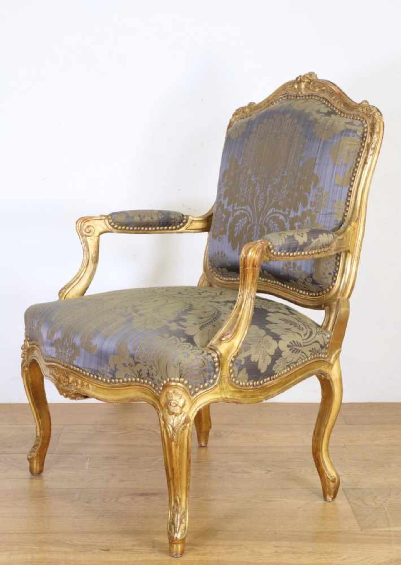 Verguld houten fauteuil in Louis XV-stijl, 19e eeuw,met blauwe damasten stoffering; Herkomst: Uit