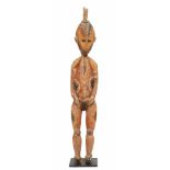 PNG, Maprik, female ancestor figure,painted in red, black, yellow and white. WIth a disc shaped