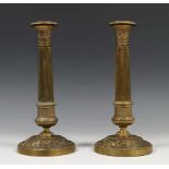 Paar vergulde kandelaars, 19e eeuw,de gacanneleerde stam op ronde voet met relief van