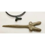 Carved antique bone pin and a bronze antique amulet;in the shape of a double phallus and small