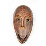 DRC., Lega, mask,in the shape of a monkey face. With pierced holes for decoration and for rafia