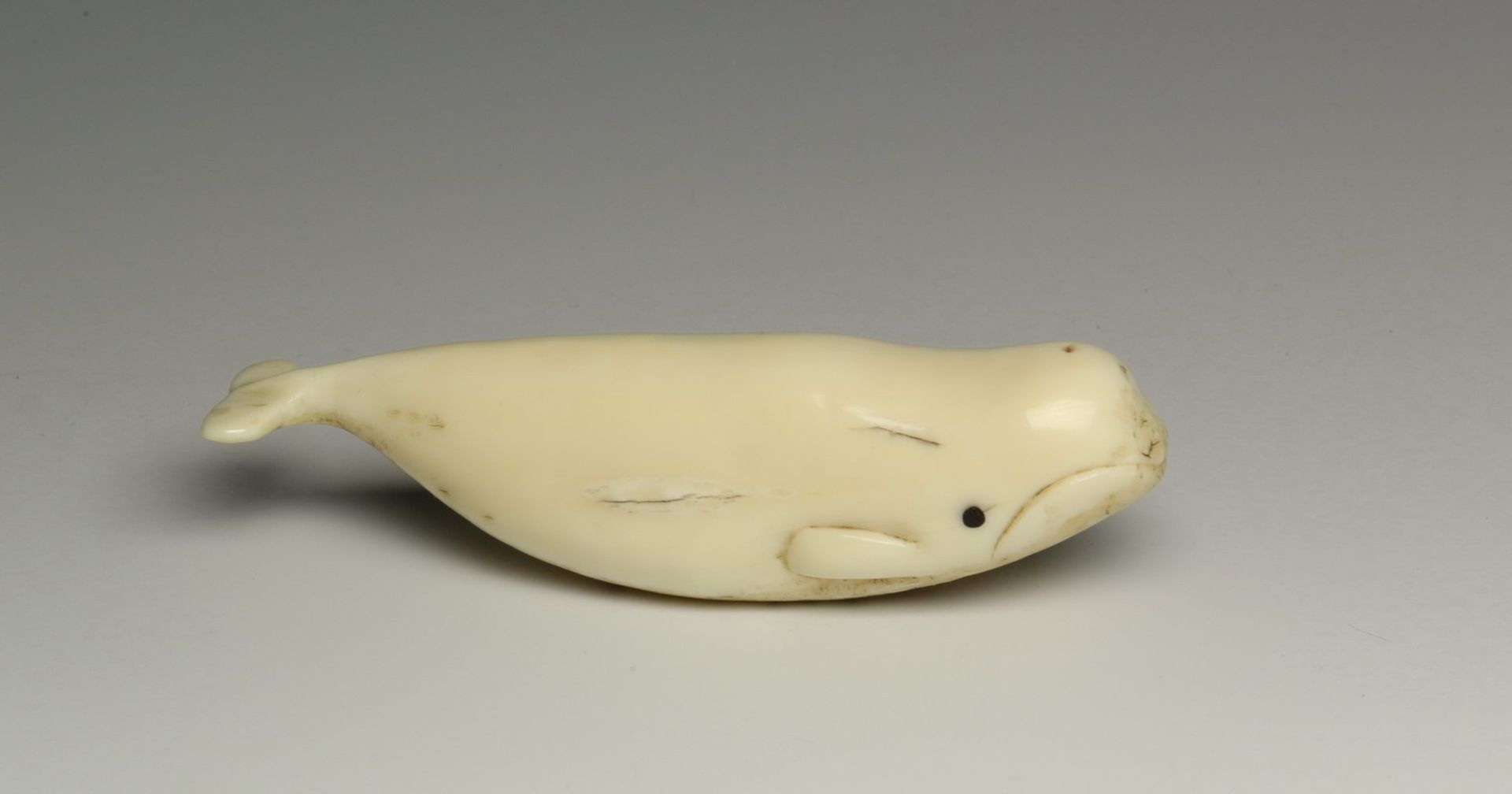 Arctic Circle, ivory toggle shapes as a whale, early 20th century.Herewith an ivory button shapes as