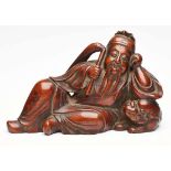 Liegender Buddha, China wohl 18. Jh.Holz, vollrd. geschnitzt. Seitl. lagernd, auf Tempellöwen