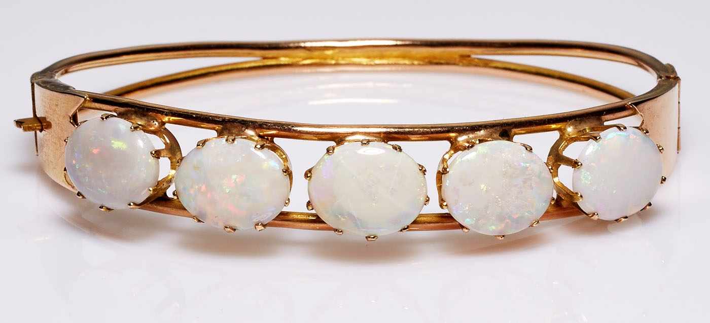 Opal-Armreif.14 kt GG, besetzt mit 5 ovalen Opalen in hohen Krappenfassungen, schmaler