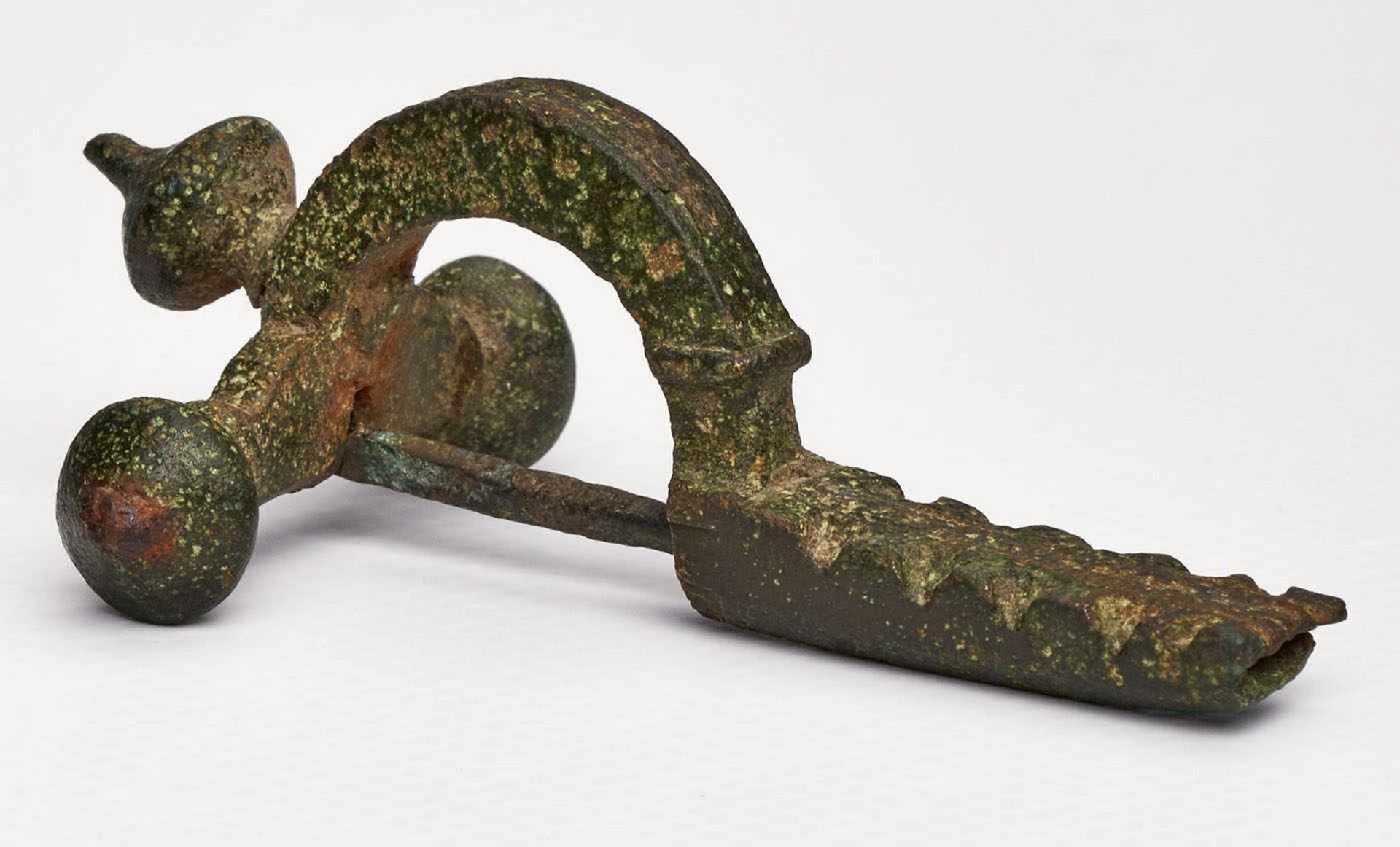Römische Zwiebelknopf-Fibel,wohl 3.-4. Jh. n. Chr. Metall (Bronze?). Typ. Kreuzform m. gewölbtem