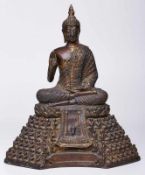 Buddha auf hohem Sockel,wohl Thailand Anf. 20. Jh. Bronze, partiell vergoldet. Im Lotossitz, eine