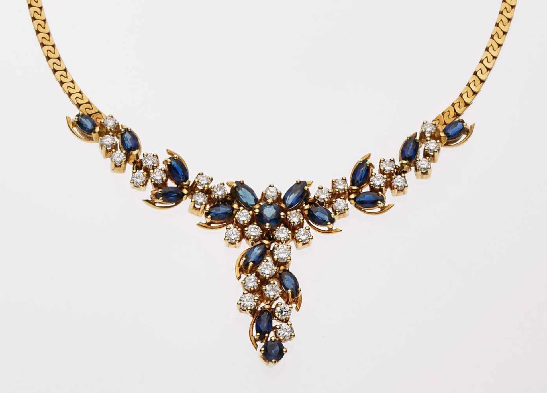 Saphir-Brillant-Collier.18 kt GG, mittig blütenrankenartiges Ornament besetzt mit 17 Saphiren im