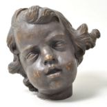 Kopf eines Putto, BarockstilHolz, vollpllastisch geschnitzt, braun gefasst. Rückseite gerissen,