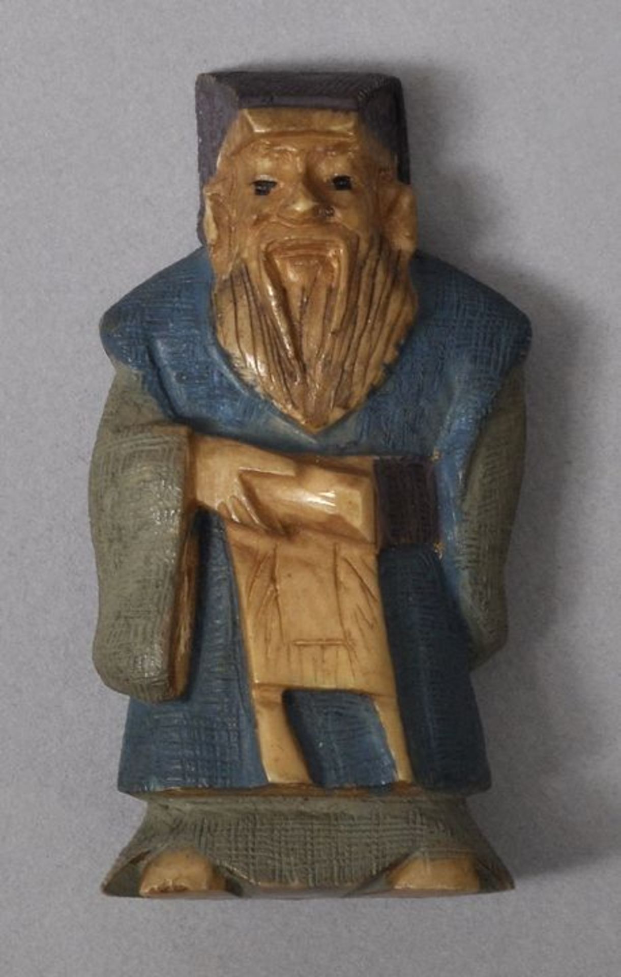 Netsuke, Japan, wohl Anf. 20. Jh.Elfenbein, geschnitzt, farbig gefasst. Gelehrter. H. 49 mm