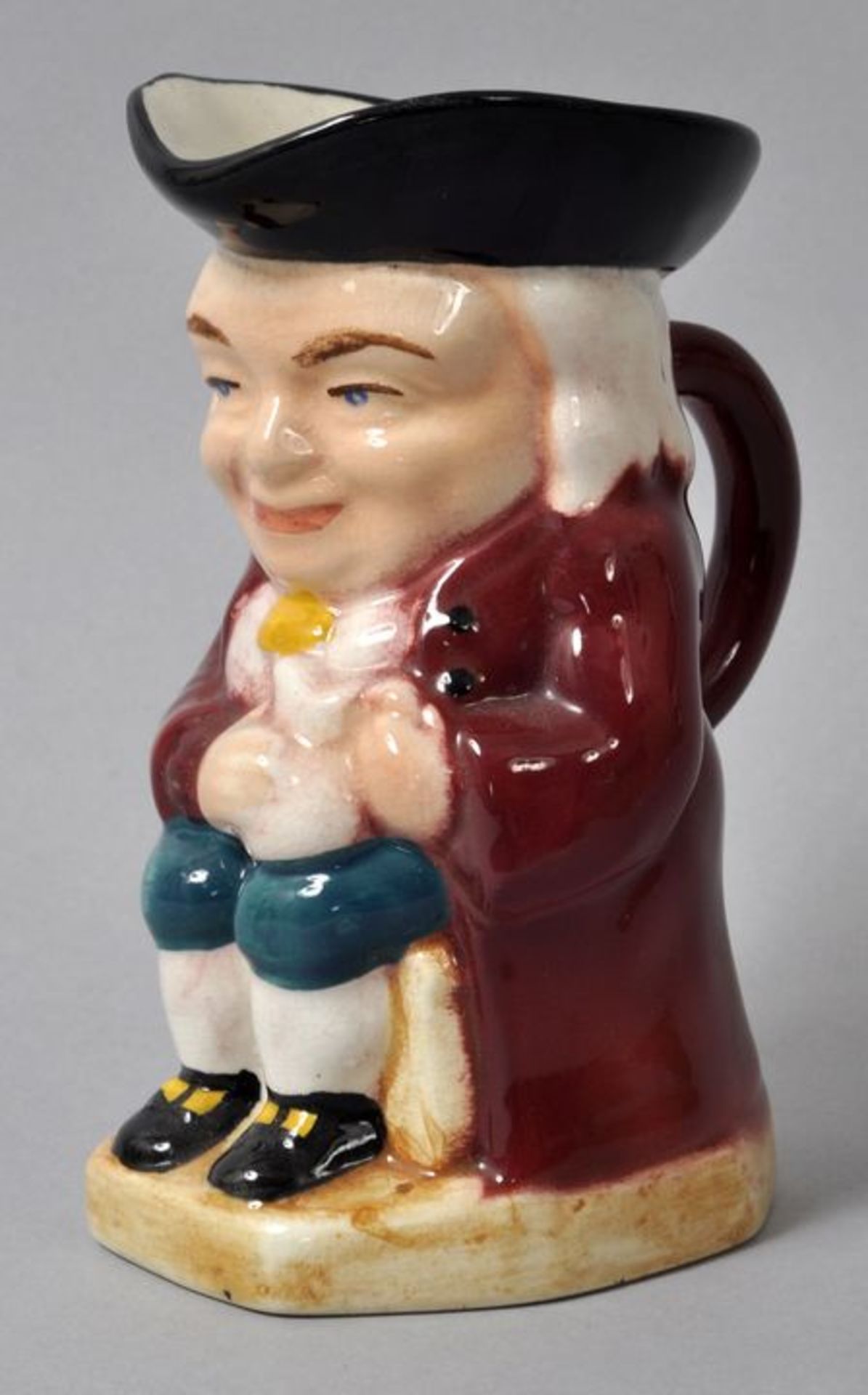 Kleiner Figurenkrug/ Toby jug, Staffordshire (?), 20. Jh.Steingut, polychrome Bemalung. Sitzender