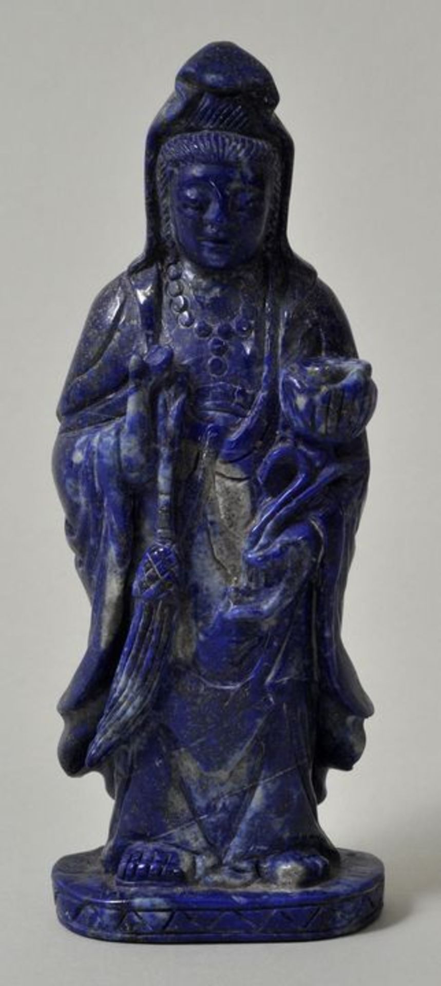 Figur einer Guanyin, China, 20. Jh.Lapislazuli. Stehende Gottheit mit Lotusblüte im Arm, H.13 cm