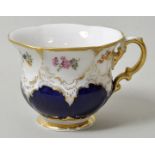 Kaffeetasse, Meissen, 1. H. 20. Jh.B-Form, untere Felder königsblau, Reliefs glanzgoldumzogen,