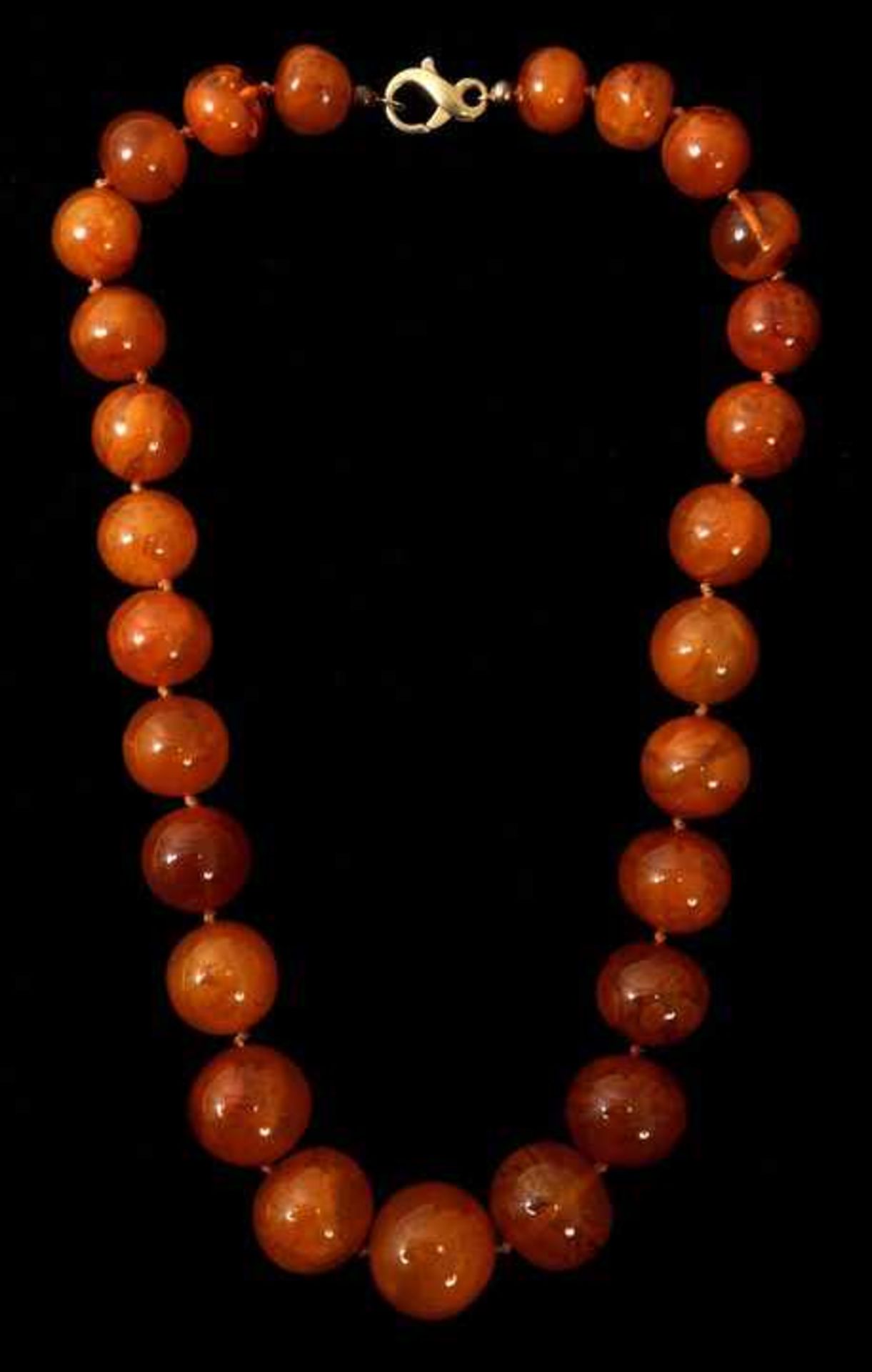 Bernsteinkette, 1. H. 20. Jh.27 große Perlen honigfarbenen Bernsteins, D. 16-25 mm, im Verlauf
