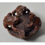 Netsuke, Japan, 19. Jh.Buchsbaum, geschnitzt. Drei kleine Frösche, auf einer runden Frucht