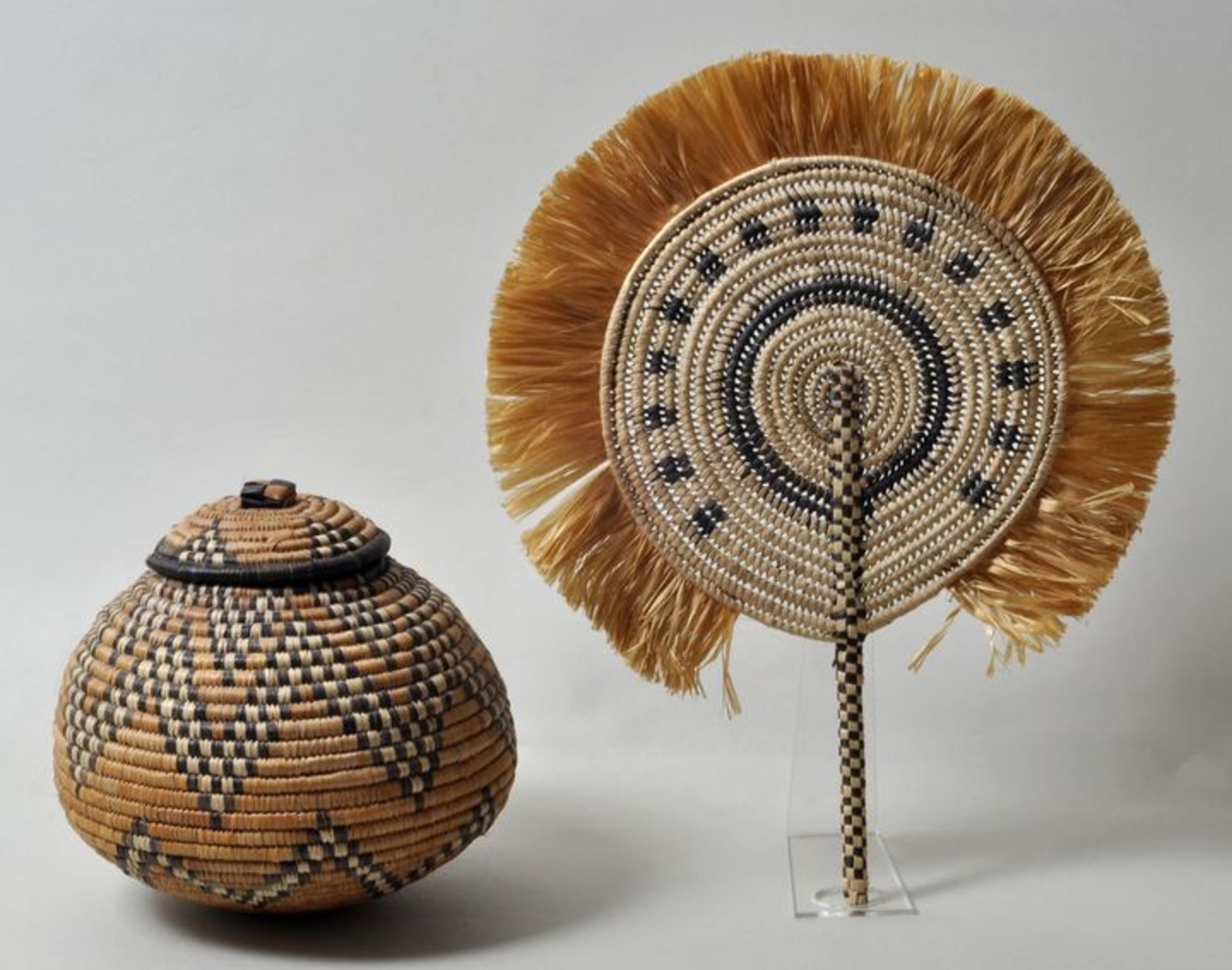 Afrika. Traditionelle Objekte.Fächer und Deckelgefäß aus Bast. Zweifarbiges geometrisches Muster.