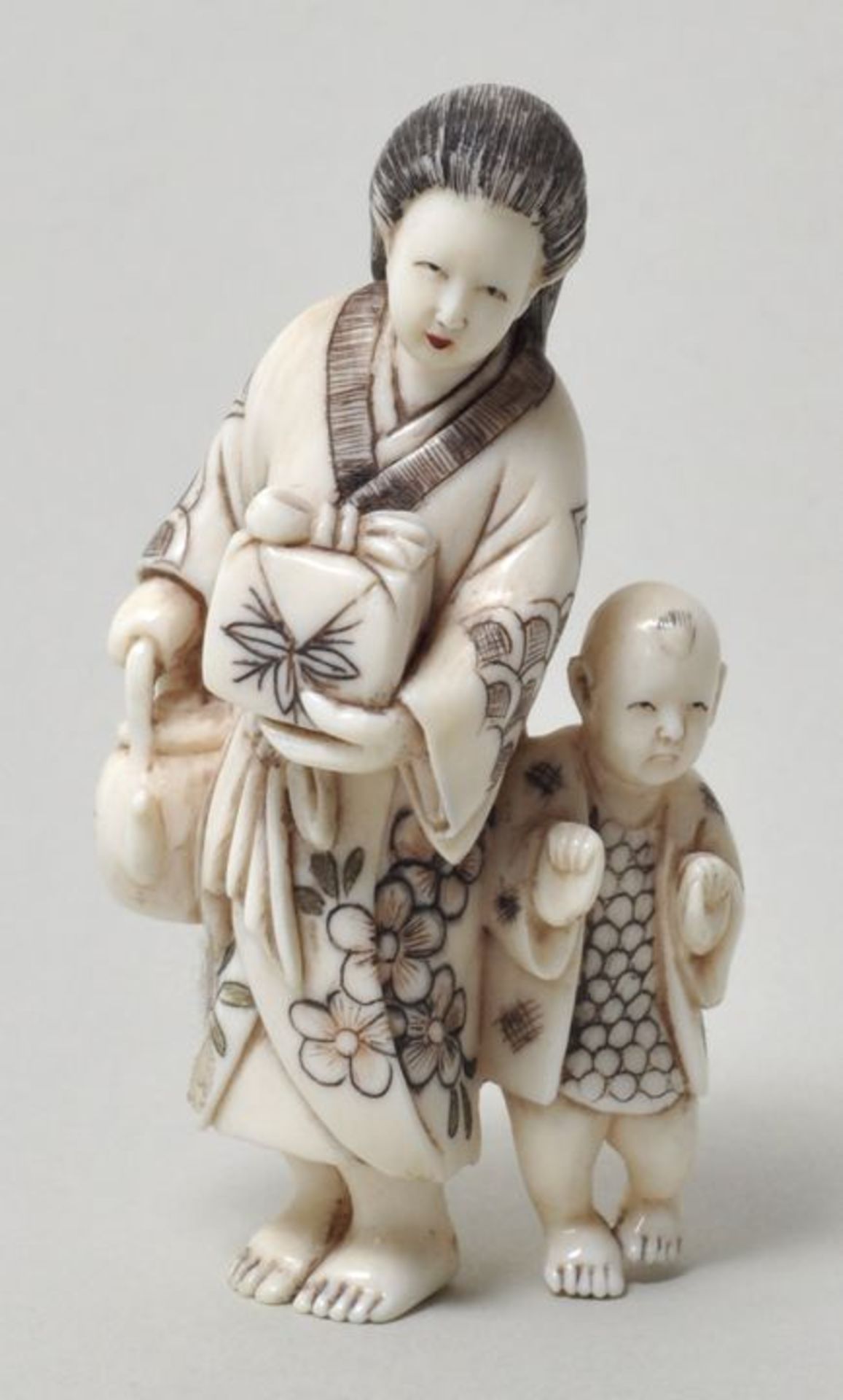 Netsuke, Japan, Meiji-Periode (1868-1912)Frau im Kimono mit Geschenk und Teekanne, begleitet von