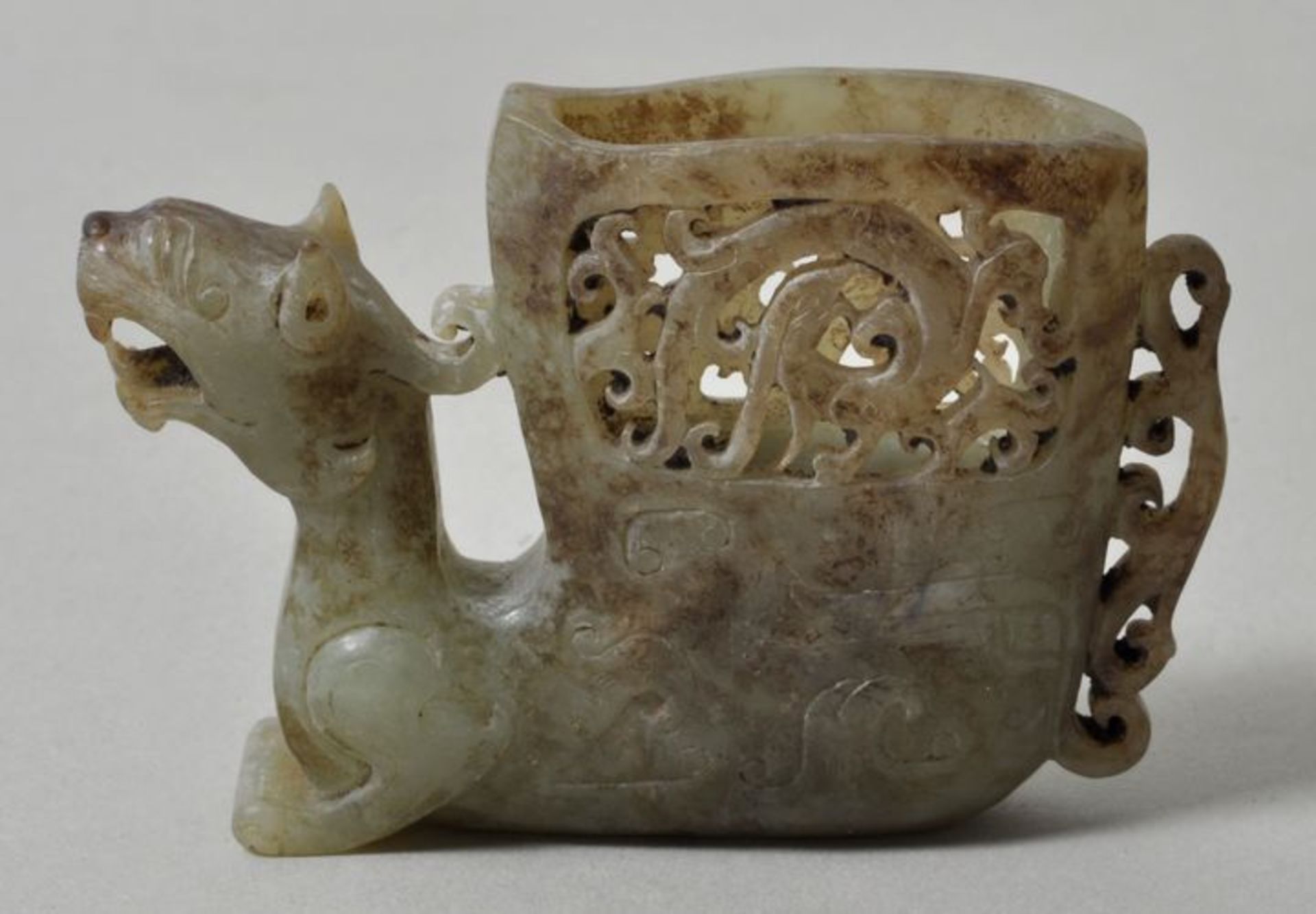 Jadeschnitzerei Drache, China, vermutl. Qing-DynastieHellgrüne Jade mit braunen wolkigen